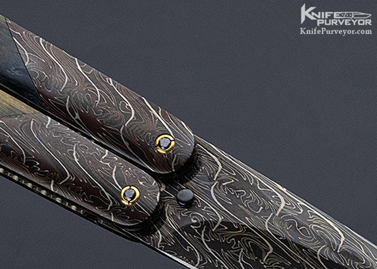 https://www.knifepurveyor.com/wp-content/uploads/2021/07/Stan-Wilson-Custom-Knife-Blue-Mammoth-and-Damascus-Balisong-11052-Reverse-Close_01.jpg